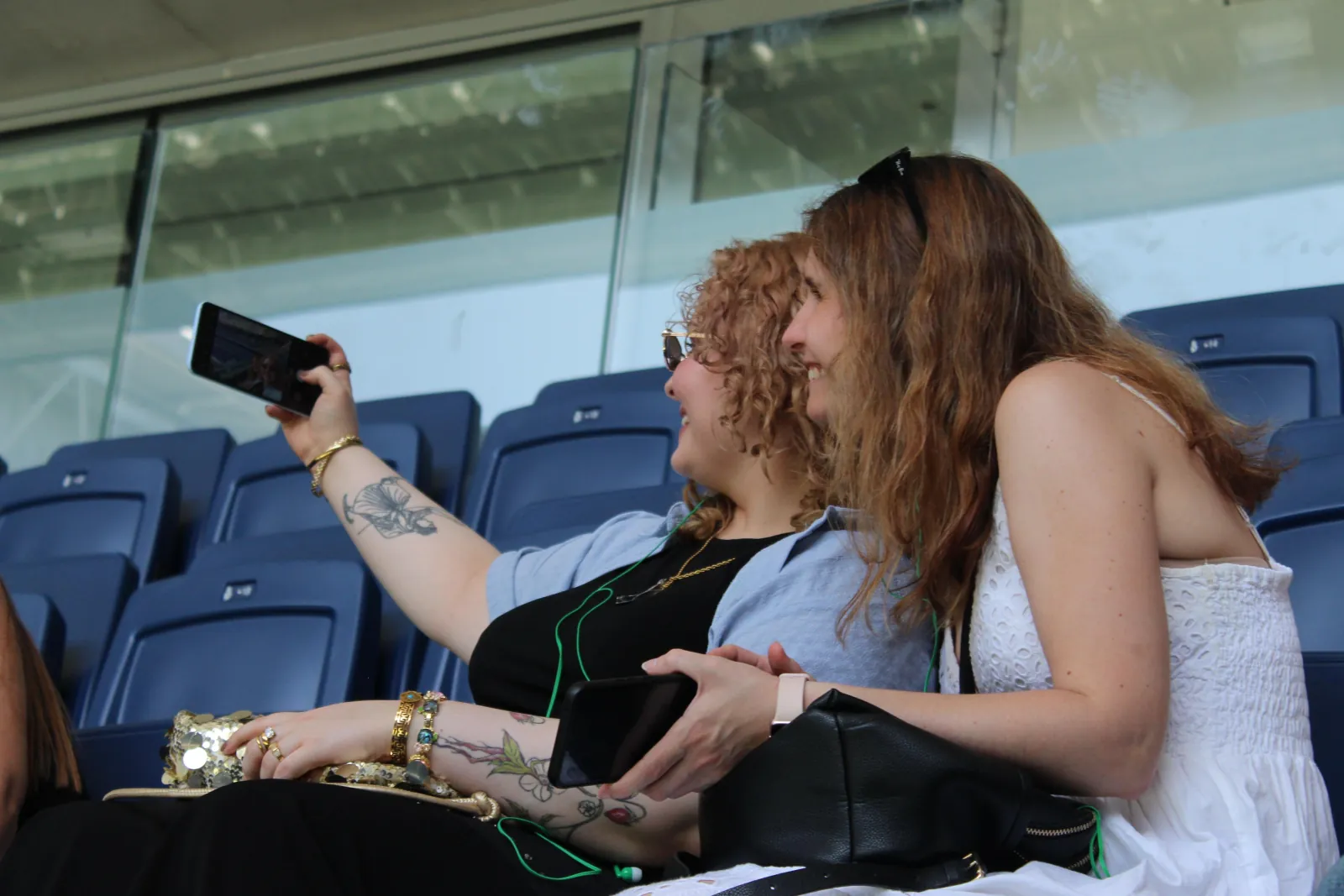 Two visitors taking photos from the Bernabéu stands during a guided tour