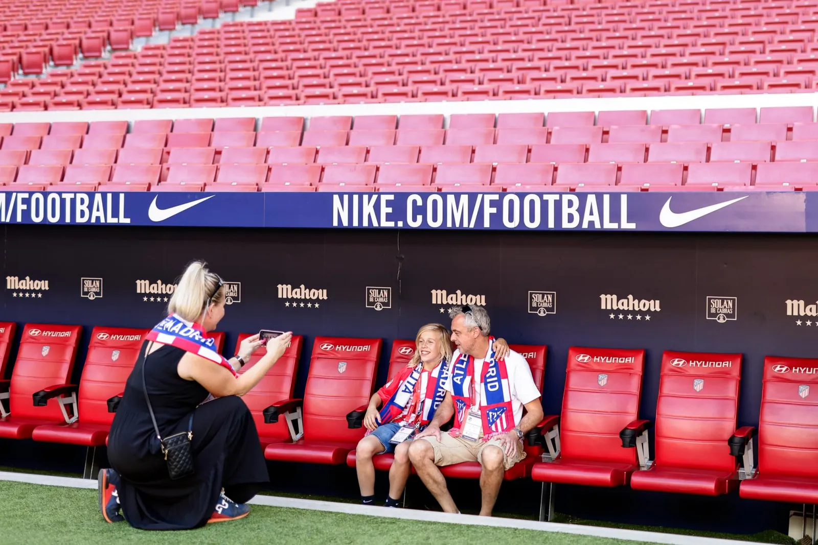 Family sitting on the Atlético bench on the stadium tour