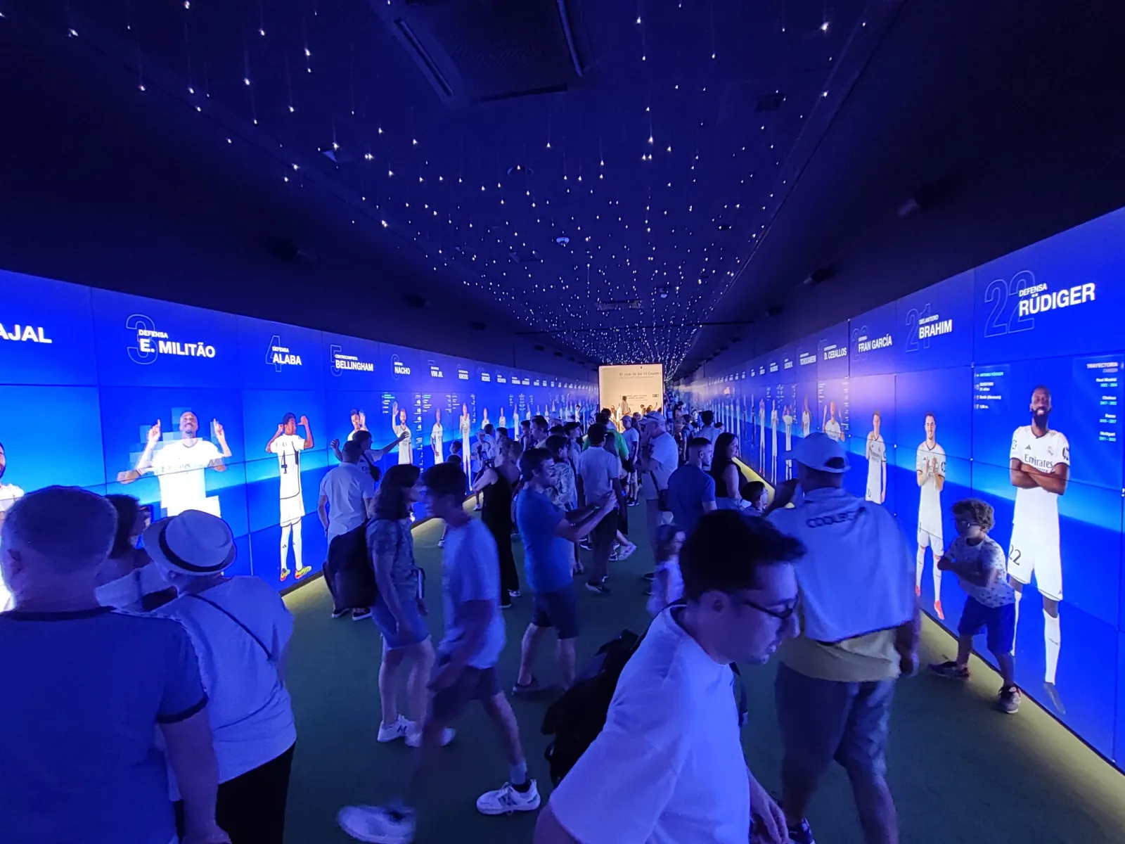 Visitors in the blue immersive player gallery of the Real Madrid museum