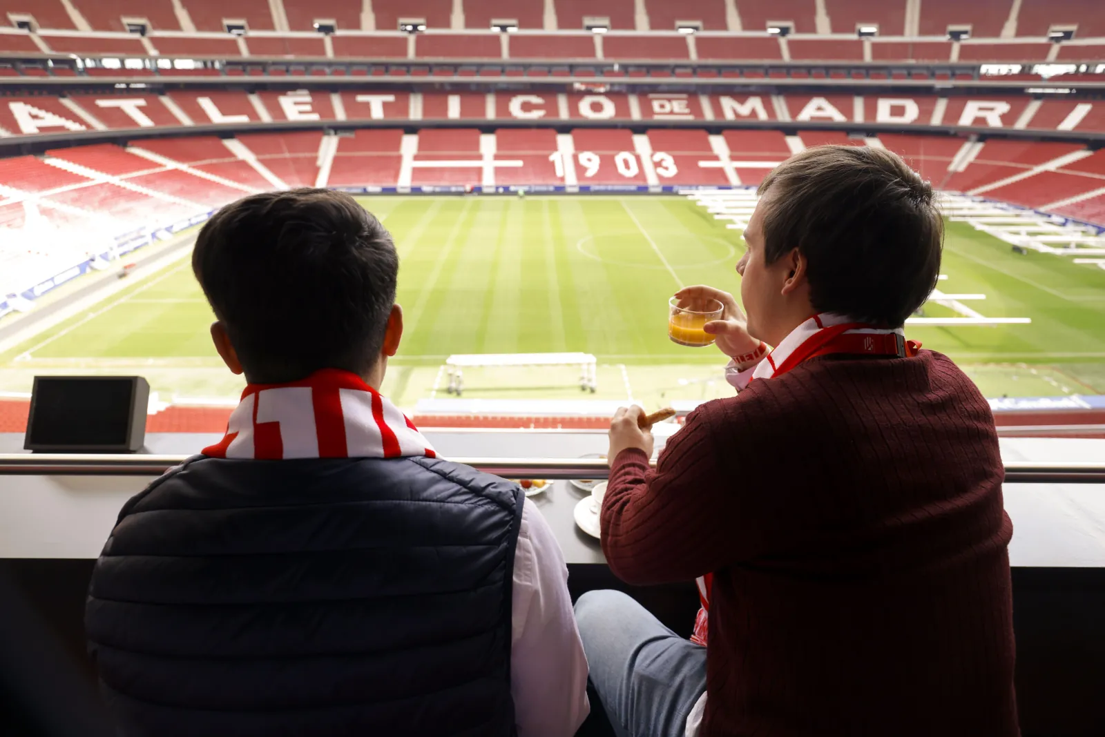 Two guests with coffee looking out over the Metropolitano pitch