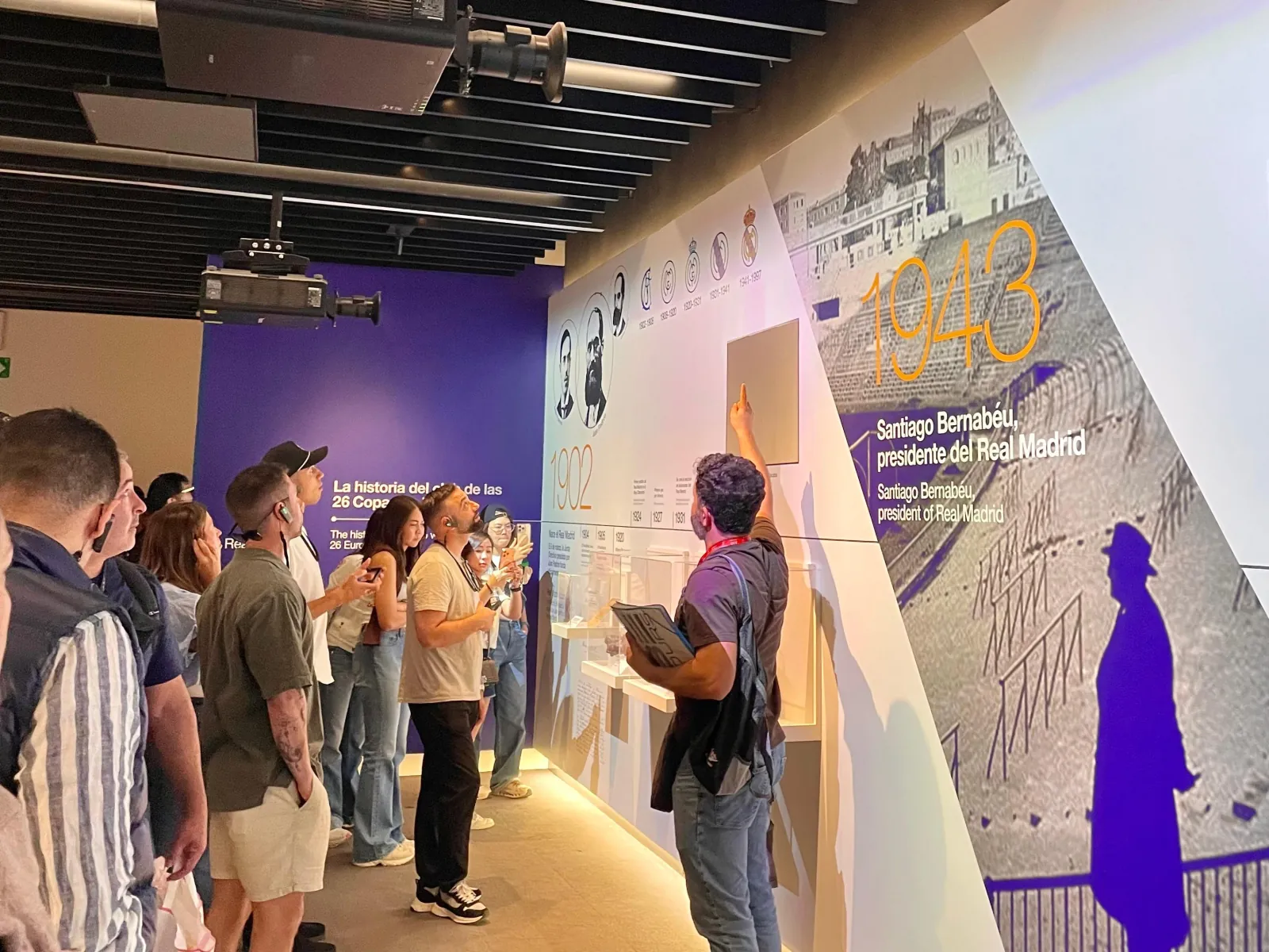 Tour group reading the Santiago Bernabéu history wall in the museum