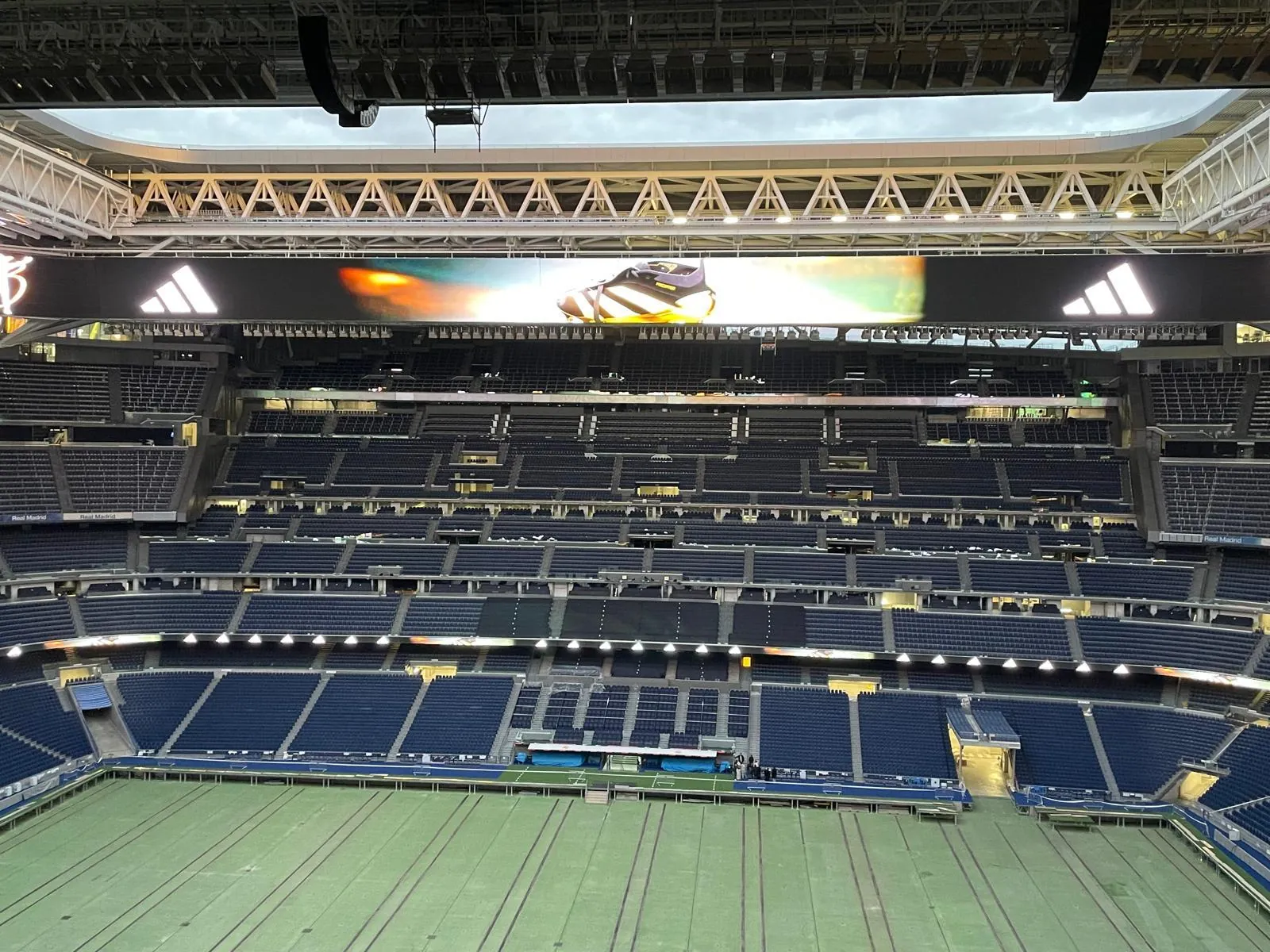 Bernabéu pitch viewed from the upper tier with advertising boards lit